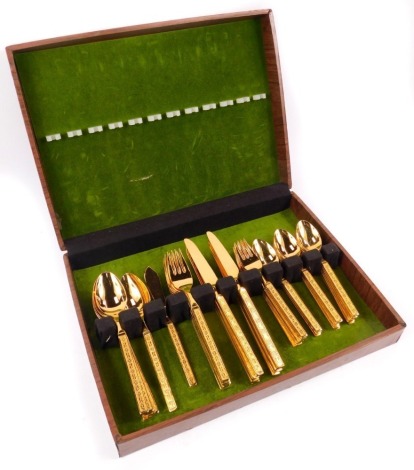 A Stanley Roberts stainless steel gilt plated canteen of cutlery, for eight place settings, each handle cast with floral and lozenge motifs, in case.