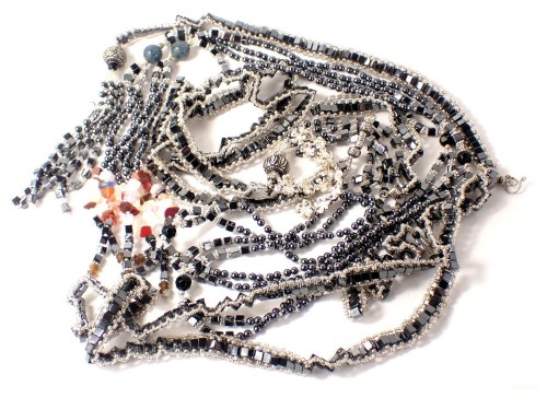 A group of costume jewellery, comprising two black metallic finished long guard chains, bracelet and a white metal coloured floral S link bracelet. (a quantity)