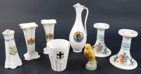 A collection of crested china, to include a pair of W H Goss candlesticks for Ipswich, an Arms of Norwich Canary by Willow Art, a pair of Arcadian Cambridge specimen vases, etc. (8)