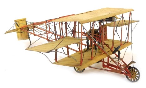 A scratch built tin plate bi-plane, in cream and red, 47cm long.