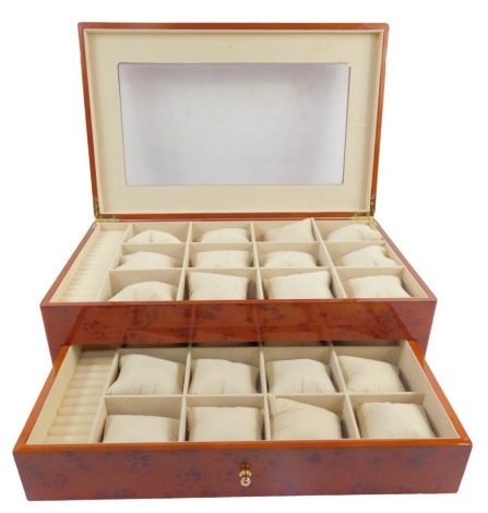 A 20thC yew finish jewellery box, the top inset with a rectangular plastic panel, the hinge lid enclosing twelve compartments for watches, beside a section for rings, the base with a drawer with various similar compartments, 46cm wide.