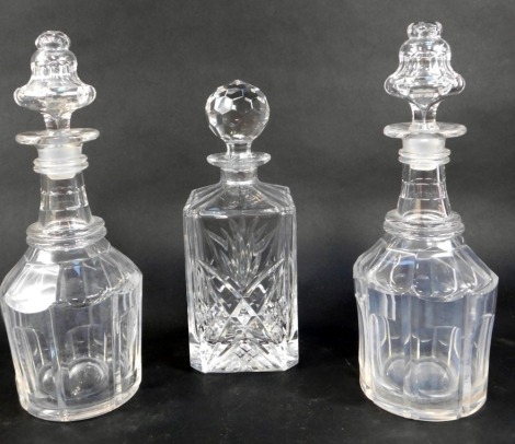 Three cut glass decanters, comprising decanter of square form, with stopper, 26cm high, and two similar mallet shaped decanters and stoppers, each 30cm high.