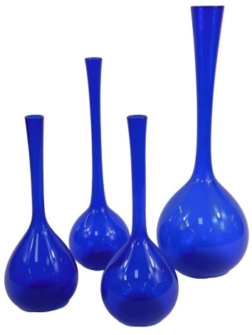 A group of blue glass vases, each of bottle form with elongated neck, the largest 51cm high.