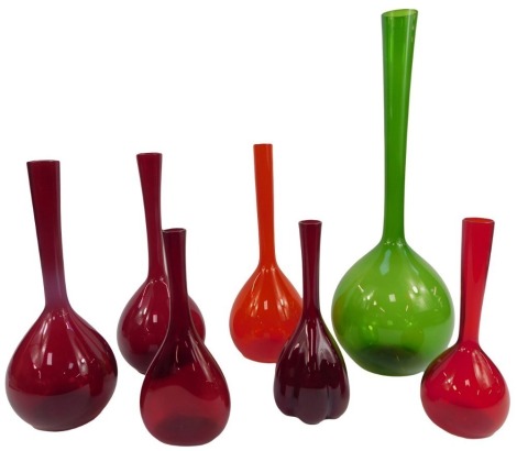 A group of glass vases, each of bottle form with elongated glass neck, in green, 50cm high, and six in red, of differing sizes.