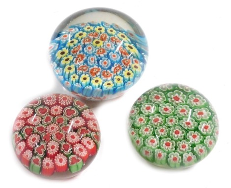 Three millefiori paperweights, in blue, green and red.