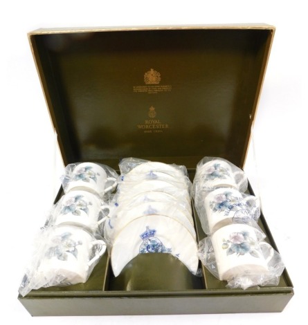 A Royal Worcester six piece coffee service, decorated with flowers against a white ground, gilt heightened, comprising six coffee cups and saucers, in presentation box.