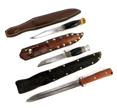 Two sheath knives and a bayonet, one sheath knife the blade stamped George Butler & Co Sheffield England, with later leather sheath, another larger sheath knife also with leather bound handle and antler pommel, and a bayonet blade with remounted grip, and