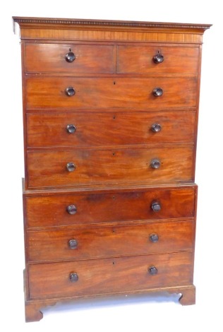 A George III mahogany chest on chest, with dentil moulded cornice, replacement knob handles and bracket feet, 200cm high, 133cm wide.