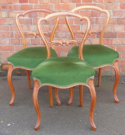 A set of three walnut balloon back dining chairs, with green Draylon over upholstered seats