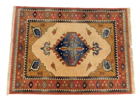 A Turkish Anatolian wool cream ground rug, with central medallion surrounded by multiple terracotta and blue borders, 140cm x 195cm.