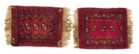 Two Persian red ground rugs, of similar design, each with three roundels within multiple borders, 64cm x 54cm and 68cm x 54cm.