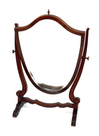 A Victorian mahogany shield shaped swing frame mirror, on scrolling supports, raised on shaped legs, 75m high.