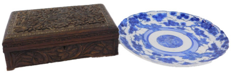 An early 20thC Oriental blue and white charger, decorated with flowering branches, impressed mark to underside, 30cm diameter, together with an Eastern carved hardwood box, the lid and sides decorated with flowers, the underside to the hinged lid stating 