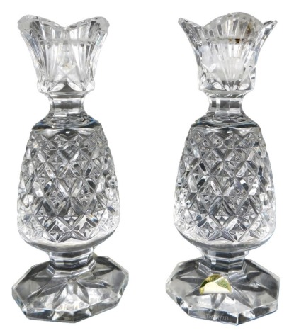 A pair of Waterford crystal candlesticks, modelled as pineapples, on octagonal bases, with paper labels, 17cm high.