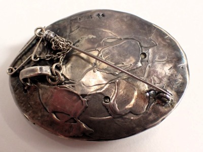 A Danish Art Nouveau oval brooch, with rub over border on mother of pearl backing shell, set with three fire opals, with leaf vine back, white metal stamped STG Sill, and bearing the initials MV, with pendant mount, safety chain, and single pin back, 5.5c - 2