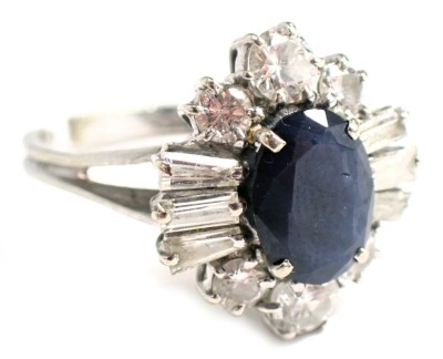 A sapphire and diamond cluster ring, the oval sapphire in claw setting, 9.4mm x 7.2mm x 3.4mm approx 1.84ct, surrounded by an arrangement of diamonds, to include two round brilliant cut diamonds, each 4mm x 4mm x 2.2mm approx 0.22ct, flanked by two smalle