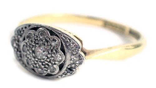 An Art Deco dress ring, the oval panel with central floral cluster, set with tiny diamonds, on a yellow metal band stamped 18ct plat, 3.1g all in.