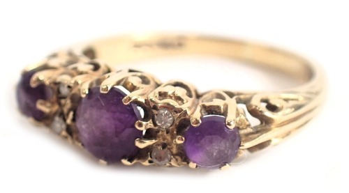 A 9ct gold amethyst set gypsy ring, set with three oval graduated amethysts and four tiny diamonds, in a raised claw basket setting, ring size P½, 3g all in.