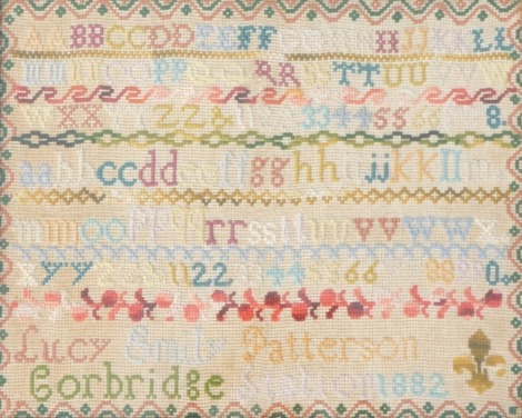 A late 19thC alphabetic wall sampler by Lucy Emily Patterson, of Corbridge station, dated 1882, 32cm x 39cm overall.