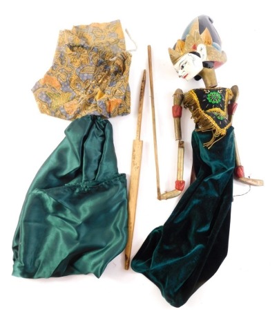 An Eastern dancing puppet, with painted wooden head, the body embellished with sequins, gold coloured braiding, etc., possibly Thai.