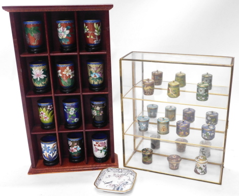 Modern Oriental cloisonne items, comprising twelve beakers, miniature storage jars and pin dish, together with associated display stands.