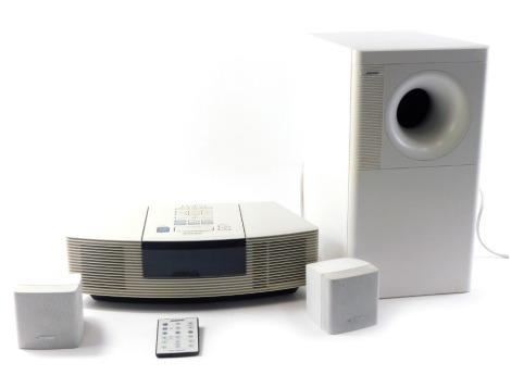 A Bose Wave radio and CD, in white, Bose Acoustimass 3 series IV speaker.