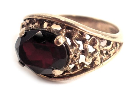 A 9ct gold garnet dress ring, with oval cut garnet in four claw setting, with bark effect shoulders, ring size N, 3.9g all in.