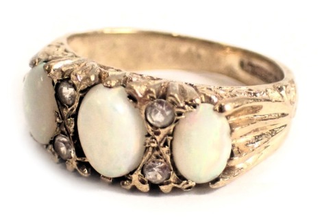 A 9ct gold opal and diamond set gypsy ring, with three oval opals and four tiny diamonds, ring size J½, 3.6g all in.