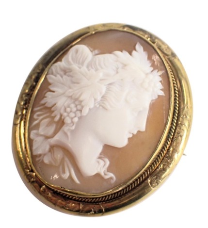 An Edwardian cameo brooch/locket, the central cameo depicting maiden looking dexter, with vine, berry and scroll hair detail, in rope twist pinchbeck border, 4.5cm x 5cm.