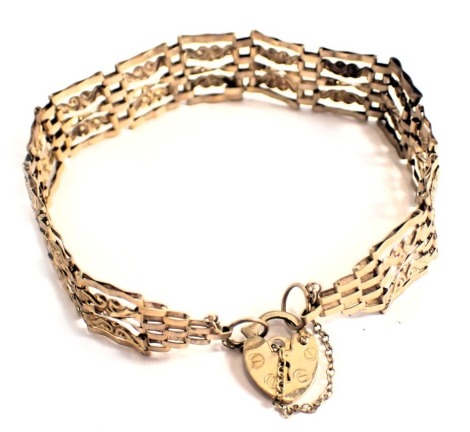 A 9ct gold gate bracelet, of five bar scroll design, with heart shaped padlock and safety chain, 18cm long, 6g, boxed.