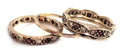 Two eternity rings, comprising a 9ct gold CZ and garnet set eternity ring, ring size R, and an opal and garnet eternity ring, ring size R, 6.9g all in, and other. (3)