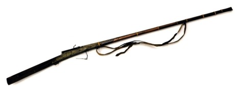 A 19thC Indian matchlock musket, with slightly flared muzzle, ram rod and leather sling, the barrel signed and with rosewood stock, 165cm long.