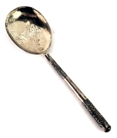 An eastern white metal serving spoon, with scroll design handle, white metal stamped SS, with weighted handle, 2.49oz gross.