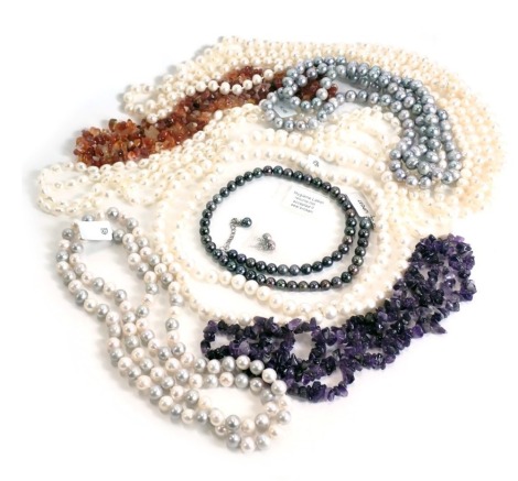 A group of cultured pearl necklaces and bracelets, cream, white and purple/blue lustre finishes, with Gemporia pouches.