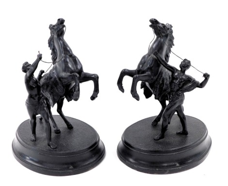 A pair of reproduction spelter marley horse type figures, each with rider on an oval hollow base, 22cm high. (2)