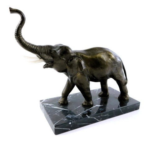 A 20thC elephant sculpture, bronzed resin finish, on a rectangular black marble base, with replacement plastic tusks, 23cm high, 22cm wide, 12cm deep.