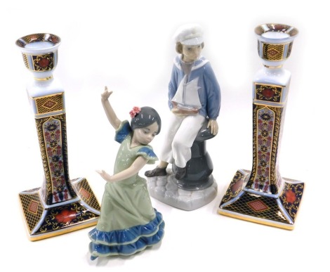 A Lladro porcelain figure of a dancer, a similar figure of a young sailor, and a pair of Imari pattern candlesticks by Roselle Occ & Co. (4)