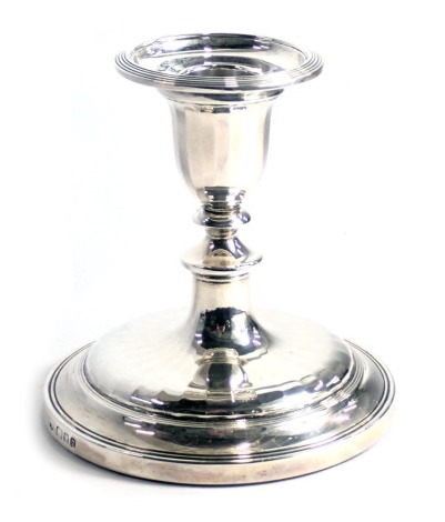 An Elizabeth II silver candlestick, of faceted form, loaded, London 1962, 12cm high.