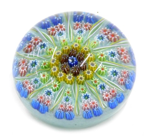 A millefiori paperweight, decorated in blue, red, green, yellow, etc., possibly Scottish, 7cm diameter.