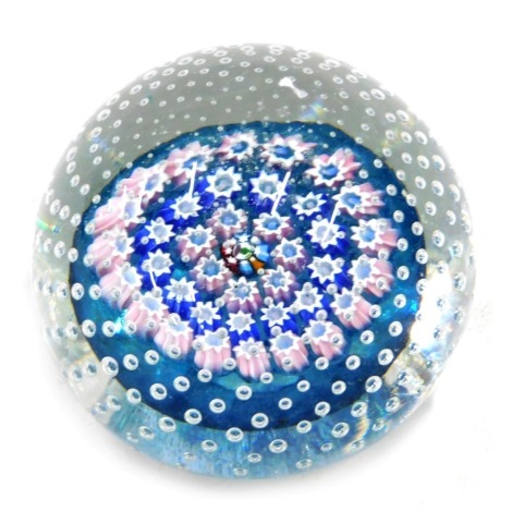 A John Deacon millefiori paperweight, with all over bubble decoration, in shades of pink and blue surrounding a multicoloured central cane decorated with a thistle, 6cm diameter.