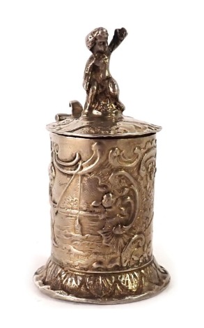 A 19thC continental silver metal miniature tankard, mounted with cherub, with embossed floral scroll decoration with fishing scene, maker ECF, import marks London 1895, 0.85oz, 5cm high.