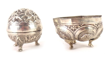 Two items of Burmese white metal, comprising a swatch pepper pot on tripod claw feet, 4cm high, unmarked, and an eastern hexagonal bowl, with hammered decoration of figures, fish and buildings, white metal unmarked, 3cm high, 1.82oz. (2)