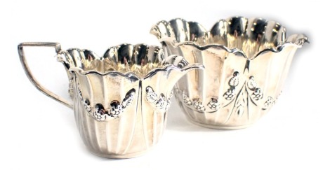 A late Victorian silver sugar bowl, embossed with swags of flowers, etc., and a matching sugar bowl, Birmingham 1899, 6.2oz.