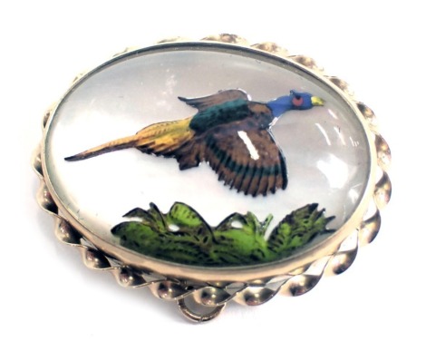 A partridge painted oval brooch, touched up with enamel decoration, on mother of pearl back, in yellow metal frame with rope twist border, stamped 9ct, 3.5cm diameter, 10.6g all in.