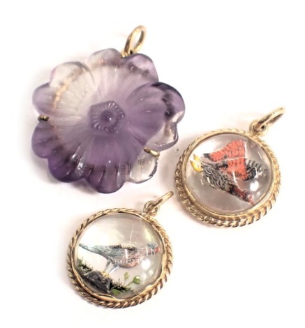 Three pendants, comprising a purple glass flower pendant and plated frame, and two mother of pearl backed bird pendants, yellow metal unmarked, 8.6g all in. (3)