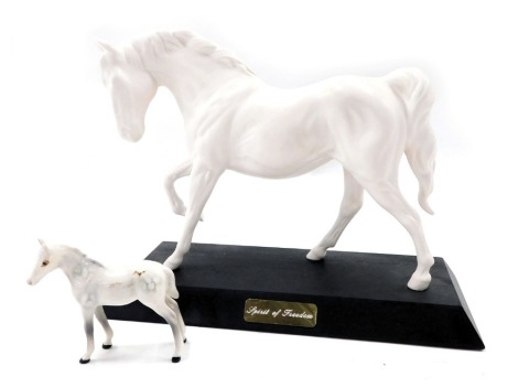 A Beswick Spirit of Freedom horse, white matt glazed, on plinth, 21cm high, 26cm wide, and a small Beswick dapple foal. (2)