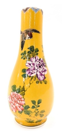 A late 19th/early 20thC Japanese earthenware bottle shape vase, decorated with coloured flowers on a yellow ground, signed to underside, 25cm high.