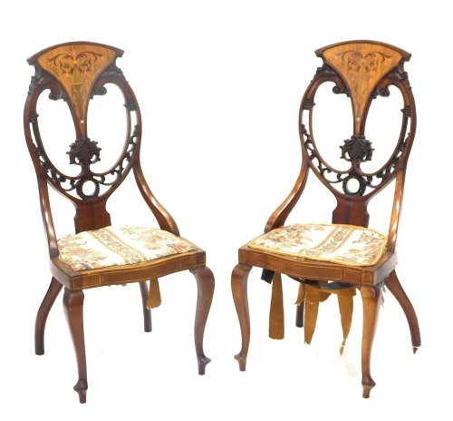 A pair of late 19th/early 20thC mahogany, satinwood and marquetry salon chairs, each with a pierced carved back and padded seat, on cabriole legs. (AF)