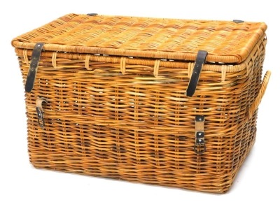 A large wicker laundry basket, with hinged lid and side handles, 95cm wide.