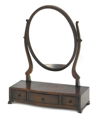 A mahogany dressing table mirror in George III style, with oval plate on shaped supports, the serpentine printed base with three drawers, on ogee bracket feet, 50cm wide.